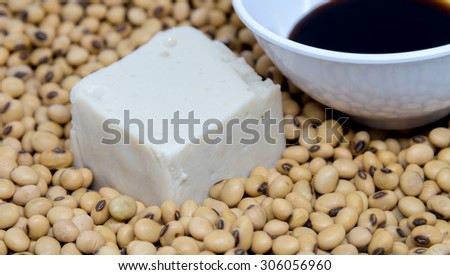 Soy tofu with soybean and soy sauce on soybeans background