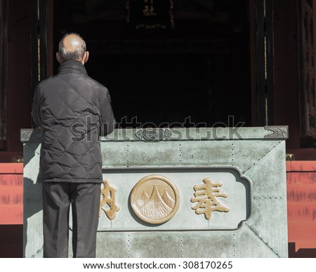 Asakusa , Japan  - February 3 ,2015 :   Unknow old man pray  in front of the shrine of Senjoji Zen style temple in Asakusa in Tokyo , Japam