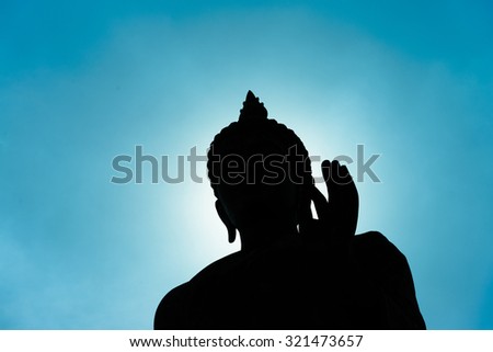 Buddha statue with dark silhouette with sunlight in evening with deep blue sky