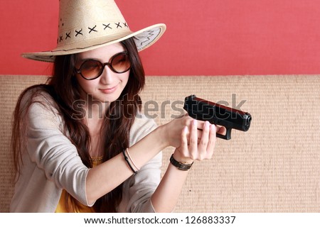 Young asian cute woman with semi-automatic pistol