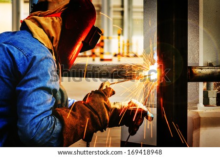 Welder working a welding metal with protective mask and sparks Welder working a welding metal with protective mask and sparks