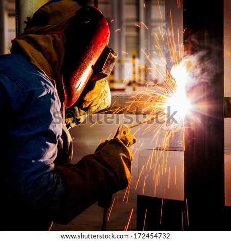 Welder Working A Welding Metal With Protective Mask And Sparks