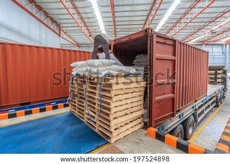 Workers working on trucks at loading meal at dock shipping industry in warehouse