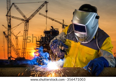 Welder working a welding metal with protective mask and sparks
