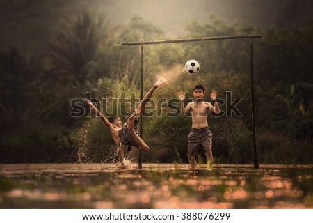 Boy playing football with kicking soccer ball