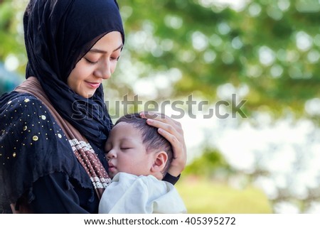 little baby sleeping in hug is muslim mother