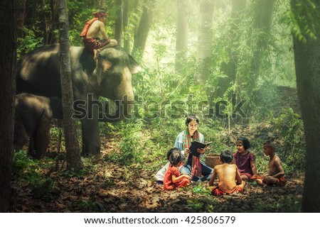 Women teacher teach children with elephant and mahout watching