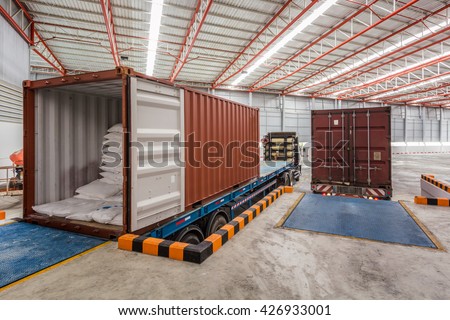 Workers working on trucks at loading meal at dock shipping industry in warehouse