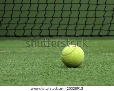 Tennis ball on synthetic grass of tennis court.