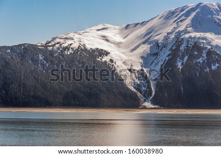 Spring melt o spruce forest, snow capped mountain, avalanche area, along the Seward Highway, Alaska.