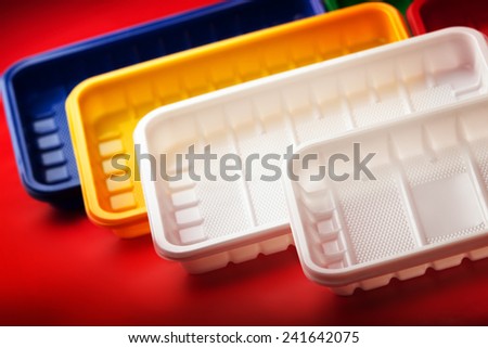 Colored plastic boxes on red background