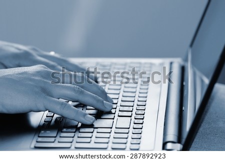 Hands on the keyboard. Office worker typing on the keyboard on the laptop.