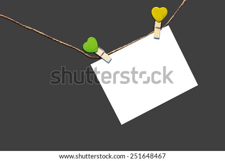 Note Message hanging on clothes line isolated on dark gray background