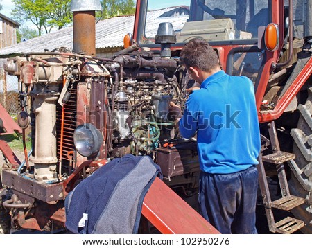 Man repairing vintage tractor engine at home