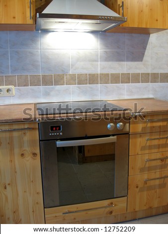 Modern electric cooker and oven in the wooden kitchen interior