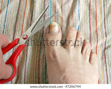 Long toe nails and hand with scissors