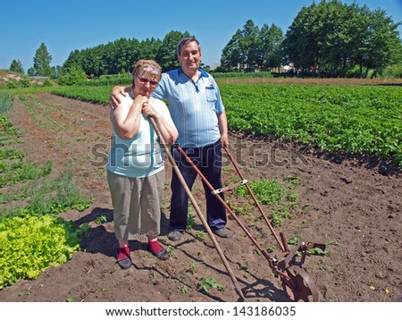 Couple of elderly country farmers with gardening tools