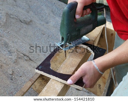 Sawing plywood by electric jig saw, close up