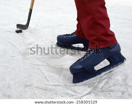 Ice hockey puck and kick and legs with skates