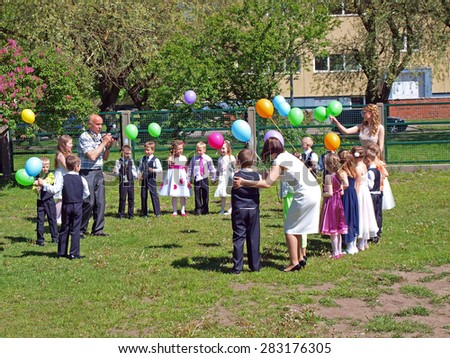LIEPAJA, LATVIA - MAY 28, 2015: Children are launching air balloons to sky on kindergarten graduation day celebrations.