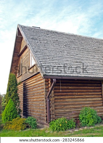 Part of log house with wood shingle roof