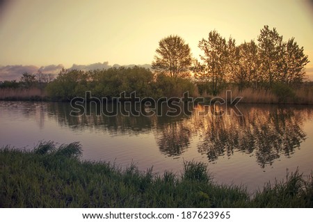 river landscape with sunset against ripple water - vintage retro style