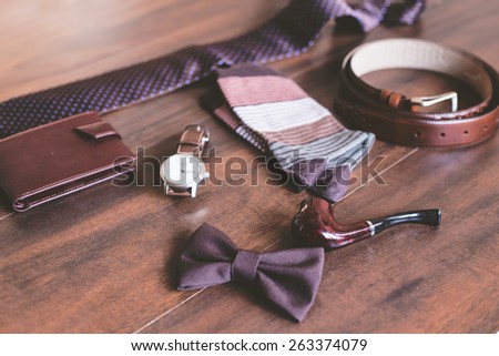 Men fashion. Men accessories. Men socks, wallet, belt, watch, tie, bow tie and smoking pipe. Still life. Business look.