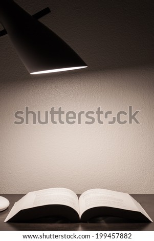 Reading book on the wooden table with lamp
