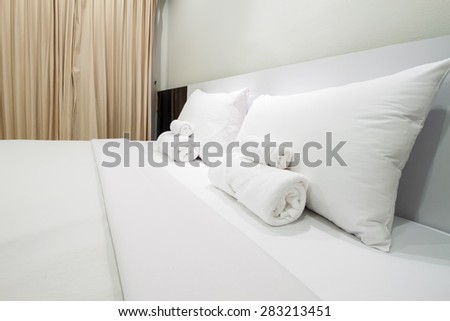 White pillows and towel on a bed