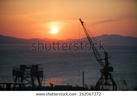 Sunset  over the Sea port of Nahodka. sea port with cranes/Nakhodka commercial sea port