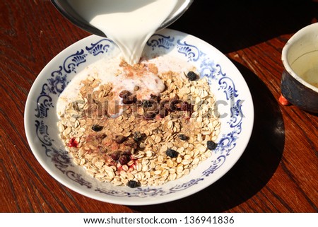 milk pouring into bowl of cereals