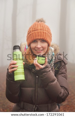 young woman drinking tea in nature