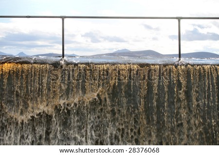 Reservoir overflowing with peat stained water in scotland