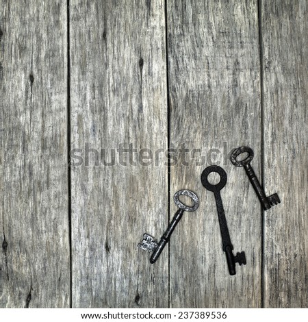 Decorative square composition with old rusty keys on wooden board. Vintage style.