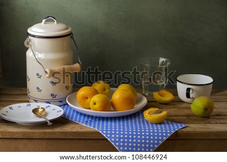 Still life with enamel can and apricots.