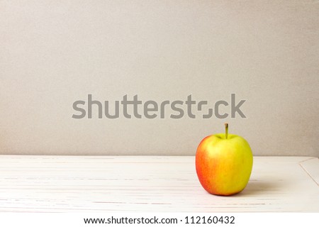 Apple on white wooden table and grey grunge background