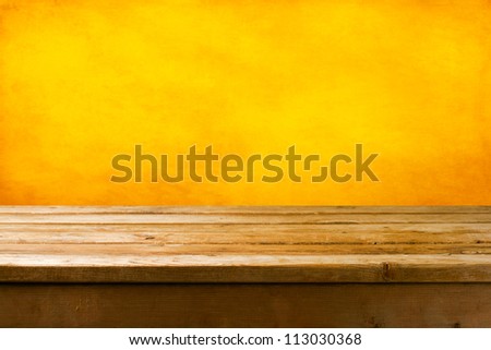 Background with wooden deck tabletop and yellow grunge wall Background with wooden deck tabletop and yellow grunge wall