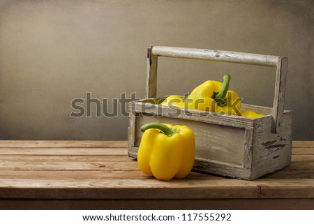 Yellow pepper in wooden box on wooden tabletop