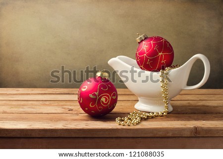Christmas background with ornaments and gravy boat on wooden table