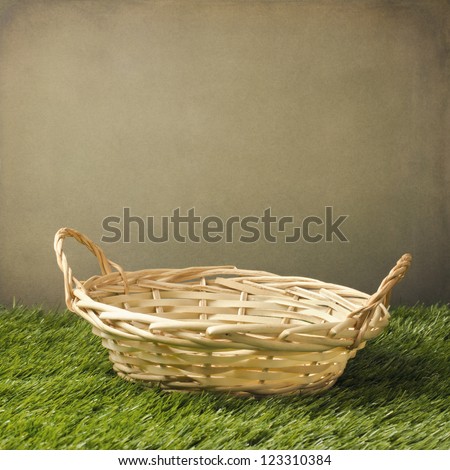 Empty basket on grass over grunge background