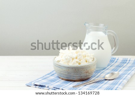 Cottage cheese and milk on white wooden table