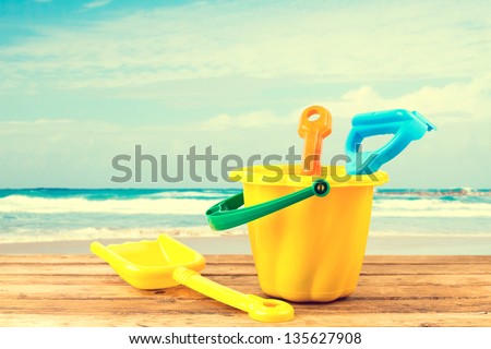 Beach items on wooden deck over sea background