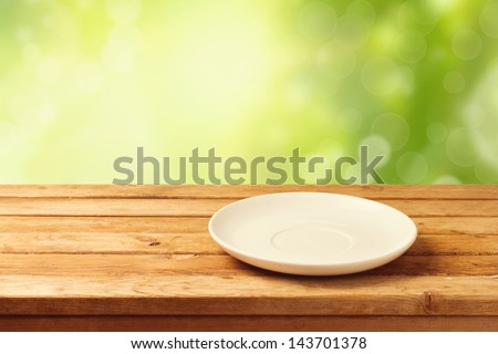 Empty Plate On Wooden Table Over Bokeh Background