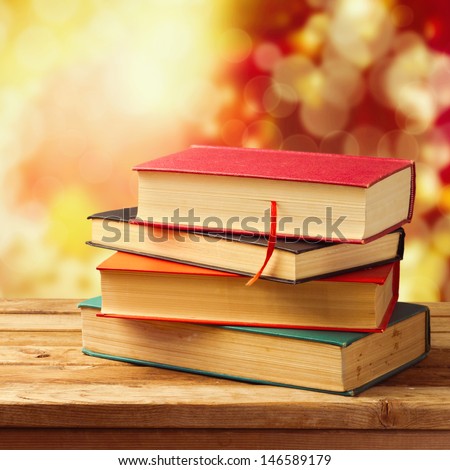 Old vintage books on wooden table over beautiful bokeh autumn background. Back to school concept