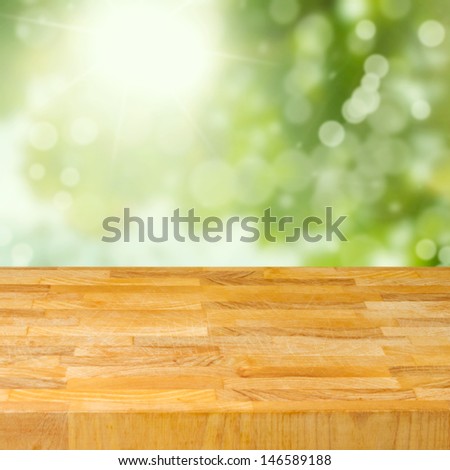 Empty wooden table over garden bokeh background. Ready for product montage
