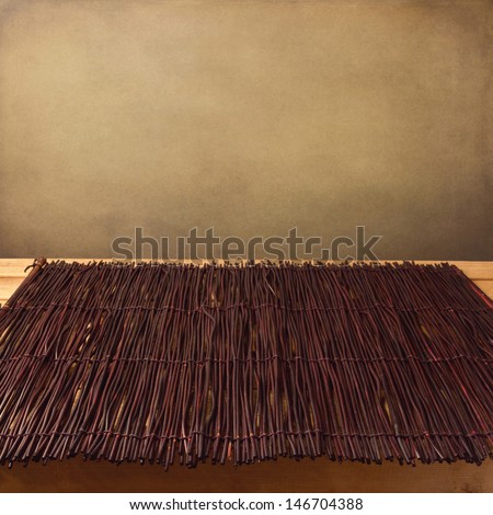 Bamboo tablecloth on wooden table over grunge background. Ready for product display montage