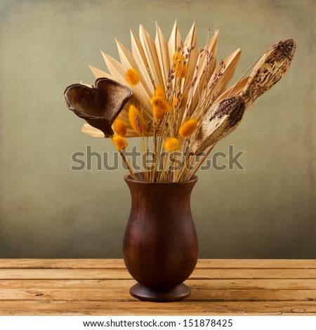 Tropical Dried Flowers In Wooden Vase Over Grunge Background