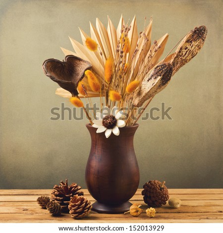 Dried Flowers In Wooden Vase With Pine Corn Over Grunge Background