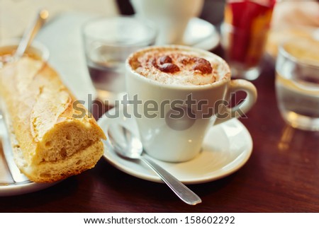 Traditional french breakfast with coffee and bread. Selective focus on cup