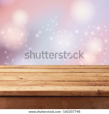 Christmas background with empty wooden table and winter bokeh background